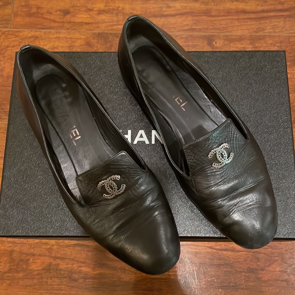 Chanel loafers in black leather with antique silver logo.